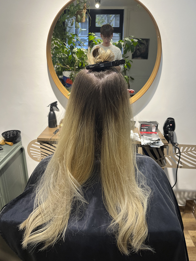 Szőke balayage hajfestés természetes sötétebb tövekkel és lágy színátmenettel. Modern, könnyen fenntartható hajszín.